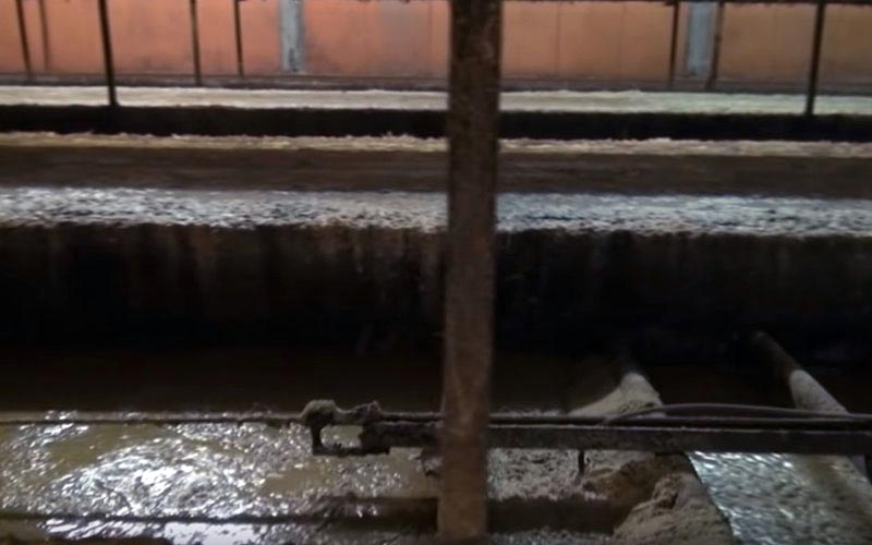 Vue rapprochée des structures métalliques et des déchets au sol sous les cages.