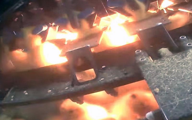 Vue rapprochée de jeunes canetons sous des lampes chauffantes dans un système industriel.